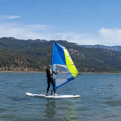 A beginner practices balance and sail control on open water, demonstrating how to learn windsurfing with a stable board and manageable sail
